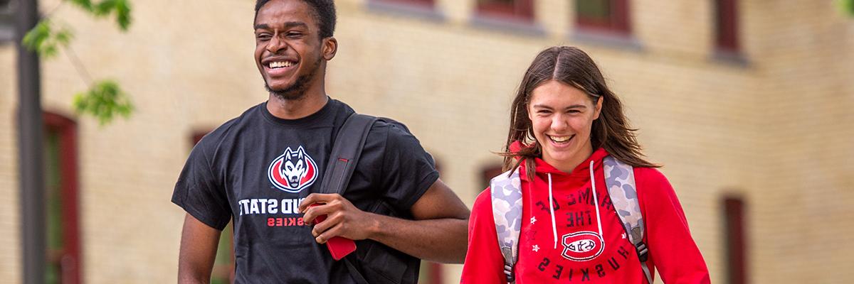 Students smiling on sidwalk